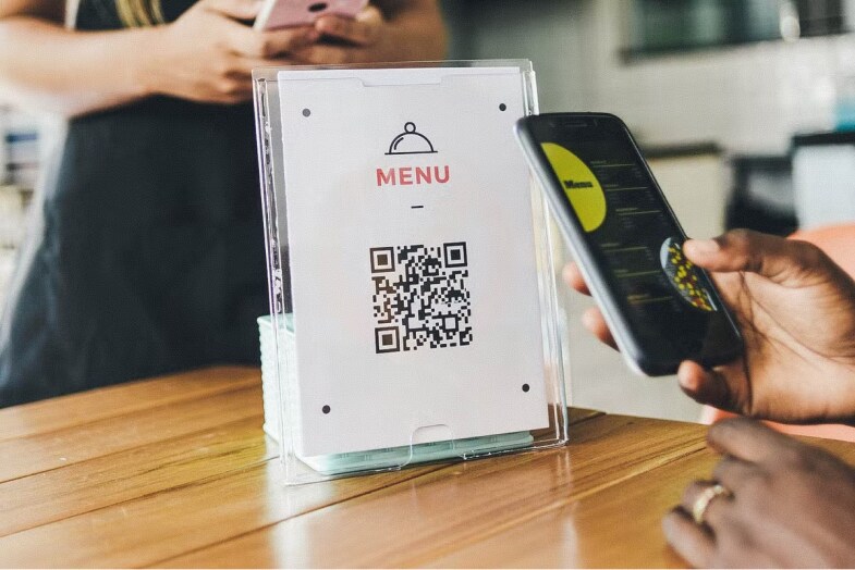 A person scanning the QR Code on the table to access the restaurant menu 