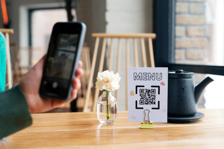 A person scanning the QR Code on the table with his mobile phone's camera