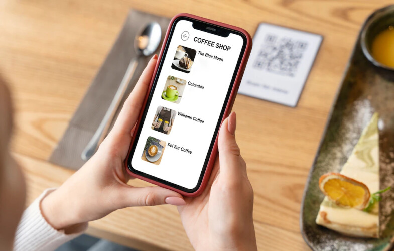 The person scanning the Qr code on the table and viewing the restaurant menu on her mobile phone